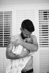 Father holds his newborn baby for first time